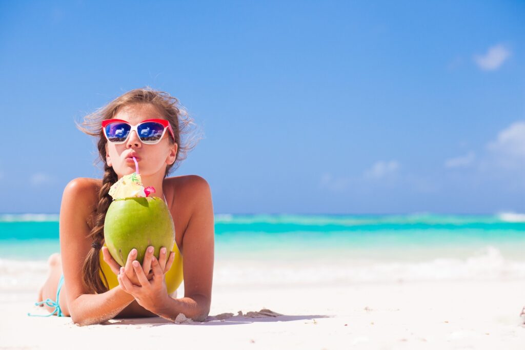young woman in sunglasses with coconut on beach Vitamin sea